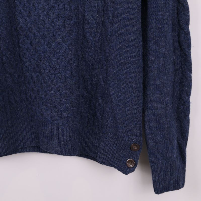 Närbild av tröjans knappdetaljer längs nederkanten