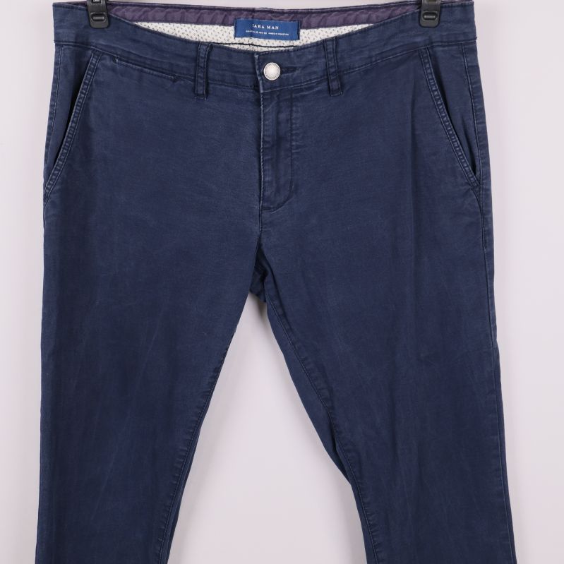 Närbild av överdelen på chinos med fickor och knapp