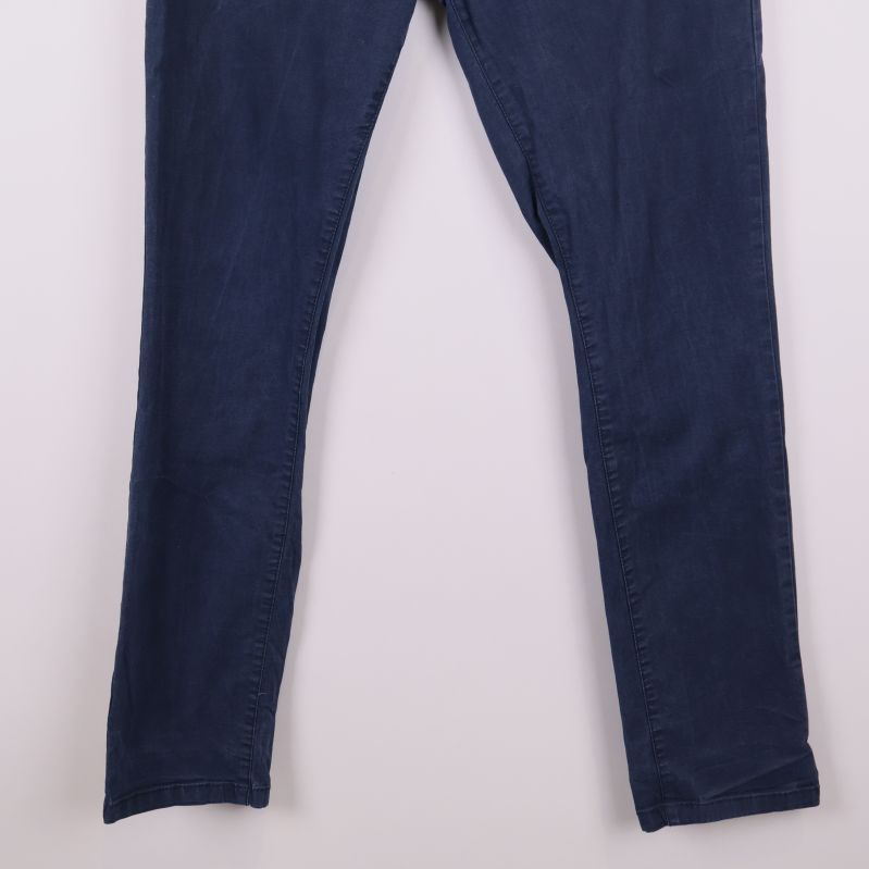 Närbild på ben och fotvidd hos mörkblå chinos