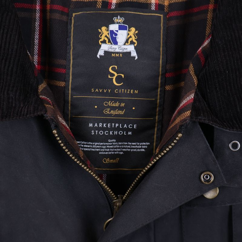 Närbild på jackans märkesskylt och rutigt foder