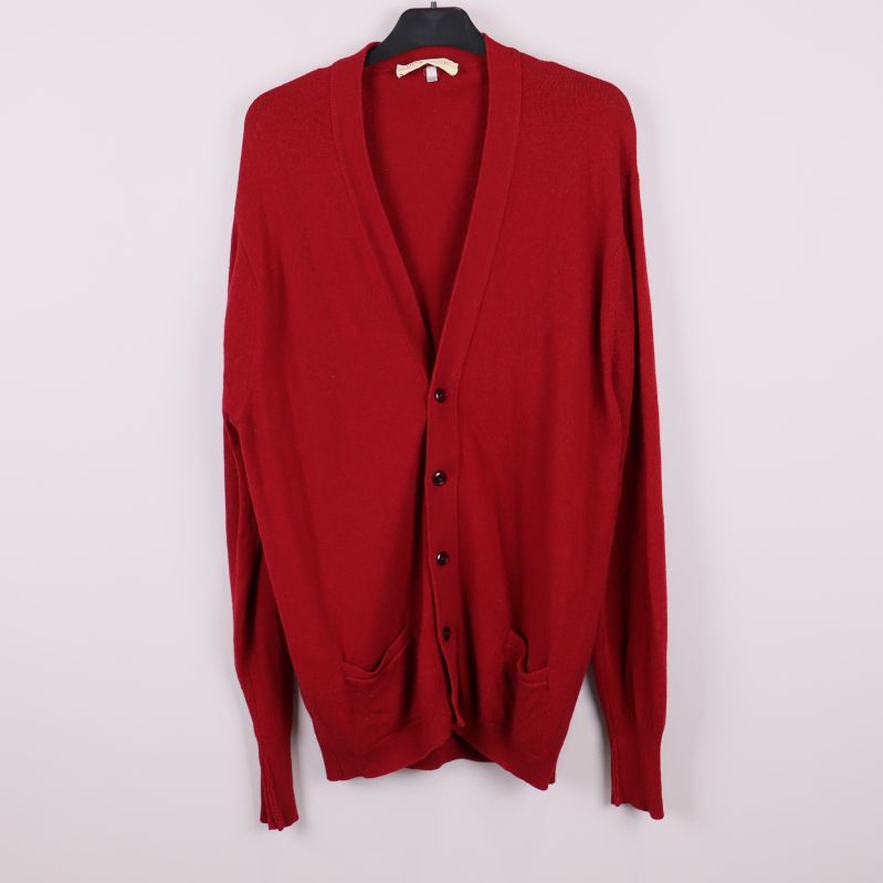 Röd stickad kofta på galge med knappar framtill