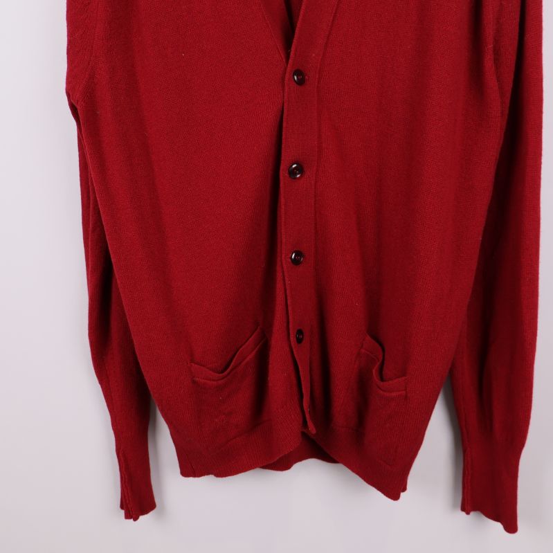 Närbild på fickor och nederkant av röd kofta