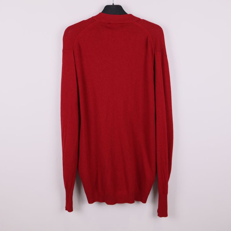 Baksidan av röd stickad kofta på galge