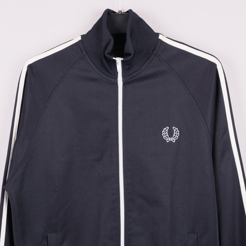 Närbild på bröstet med vit Fred Perry-logotyp