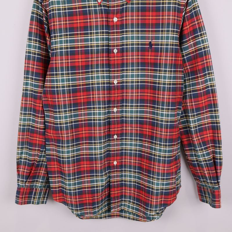 Nedre delen av rutiga skjortan i färgstarkt tyg och knappdetaljer