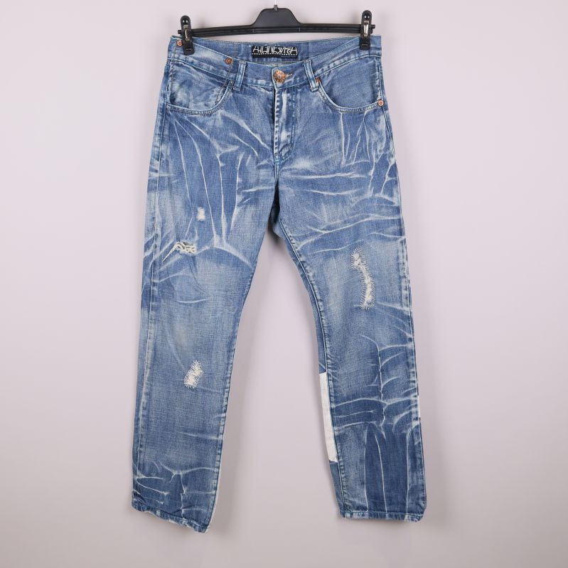 Framsidan av ljusblå jeans med slitningar och unikt mönster