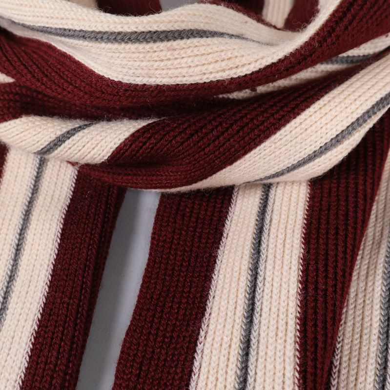 Detaljerad närbild av stickad halsduk i vinrött och vitt