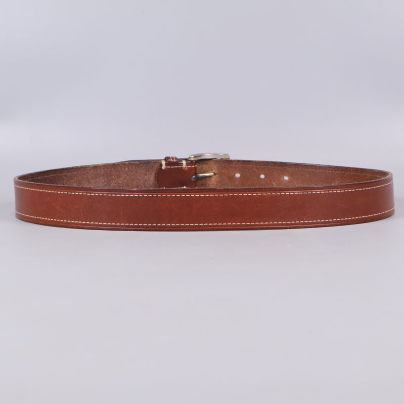 Baksidan av brunt läderbälte med vita sömmar syns tydligt