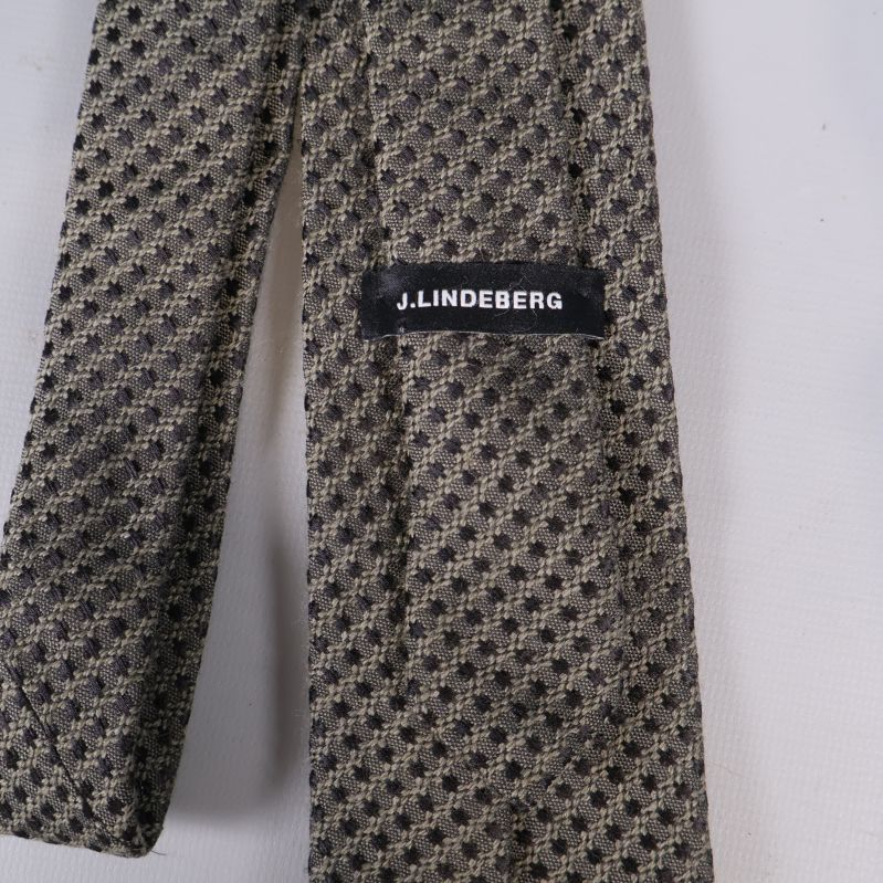 Närbild på J.Lindeberg etikett på baksidan av slipsen