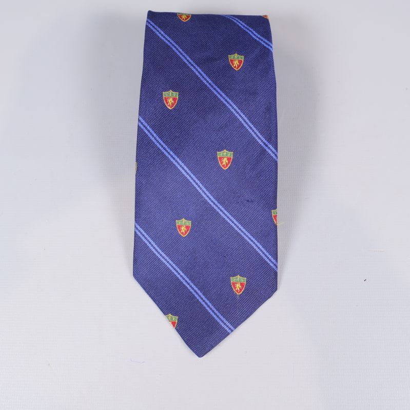 Närbild på slipsspets med emblem och ränder