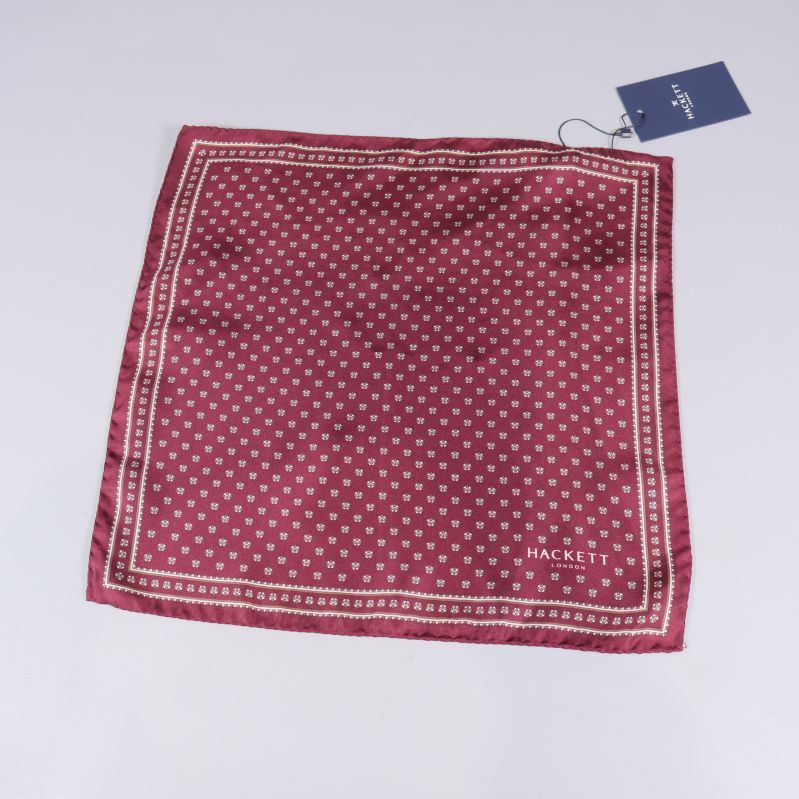 Röd näsduk med små mönster och vita ramar utlagd