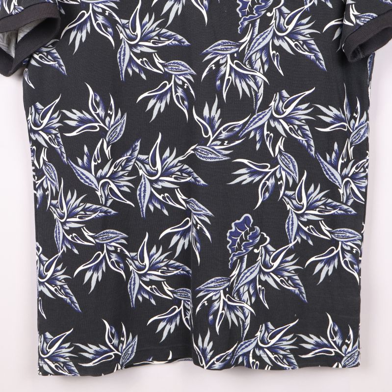 Närbild på pikétröjans blommönster och material