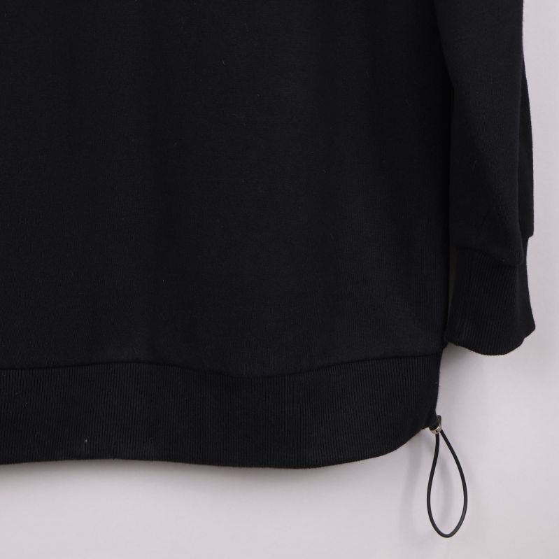 Detalj av nederkant på svart sweatshirt med dragsko
