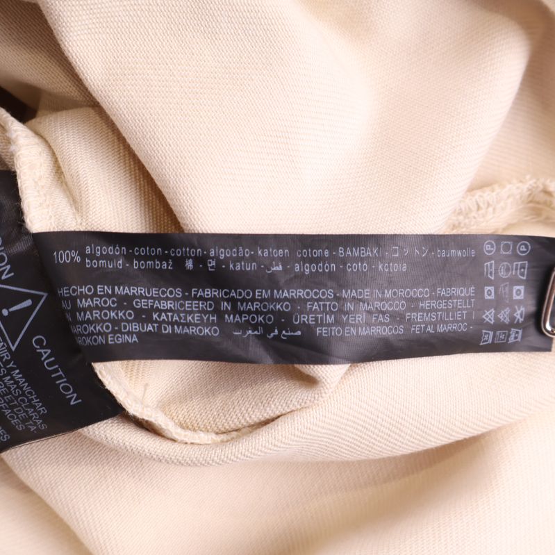 Materiallapp som visar 100% bomull på flera språk