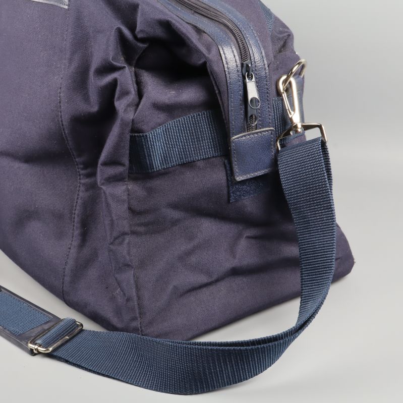 Närbild på metallspänne och del av axelrem på bag