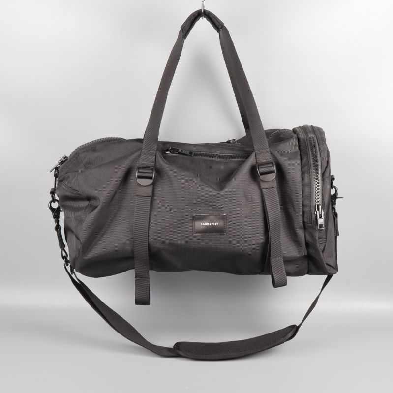 Svart sportväska upphängd med dubbla handtag och axelrem