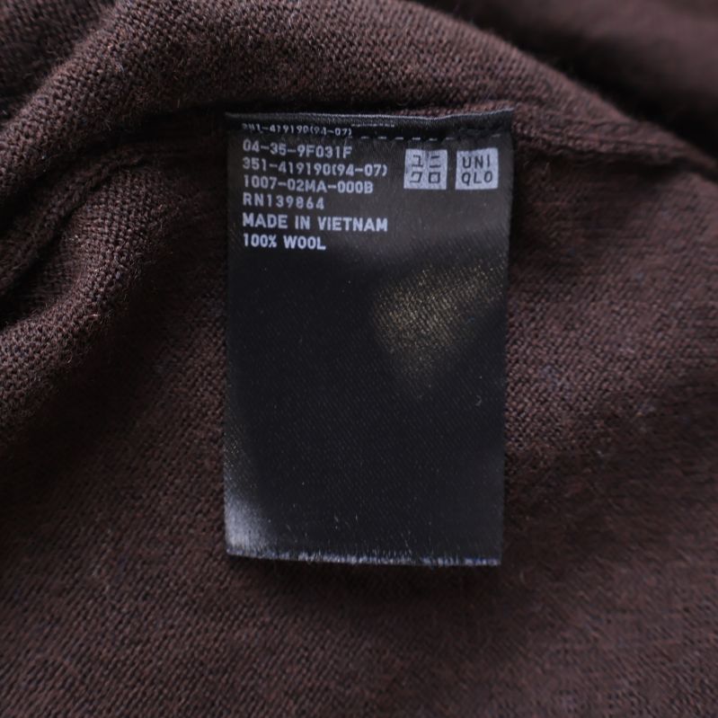 Materiallapp med texten 100% ull på insidan av brun tröja