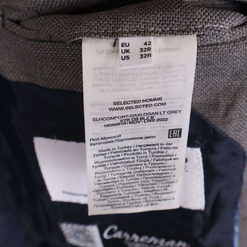 Material- och storleksetikett med information på grå kavaj