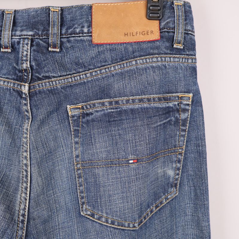 Bakfickor av blå jeans med logotyp