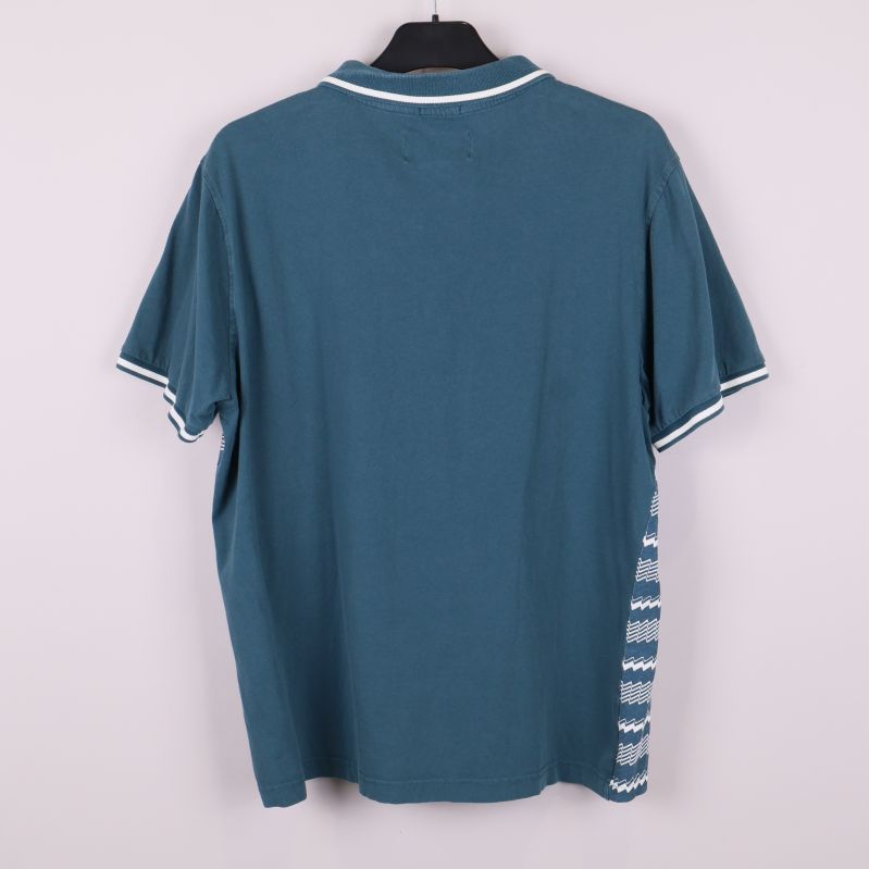 Baksidan av enfärgad blå pikétröja med vita detaljer