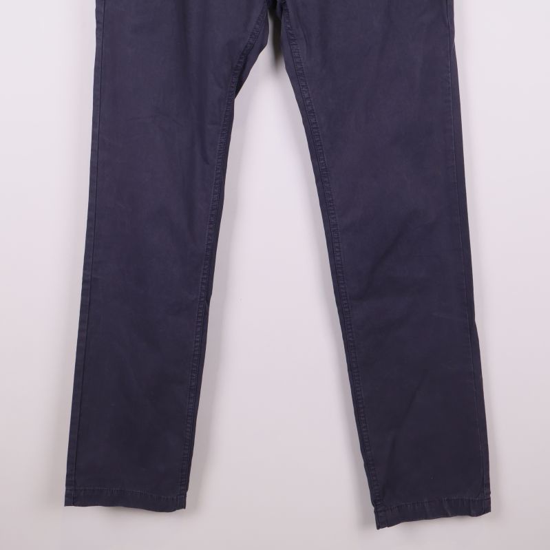 Nedre del av benen på mörkblå slim fit byxor