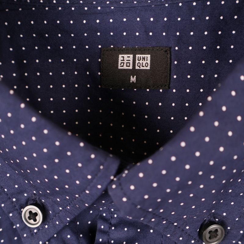 Närbild på Uniqlo-märke i kragen på skjortan