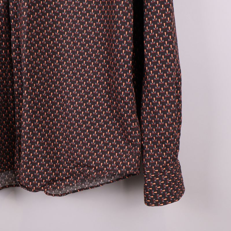 Ärm och nederkant av skjortan visas i detalj