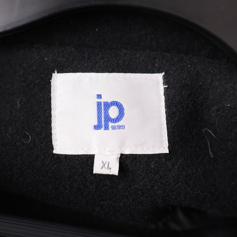 Närbild på etikett med blå jp logotyp och XL storlek