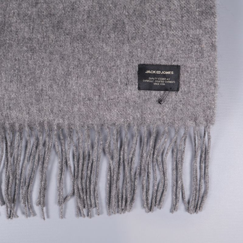 Närbild på halsdukens franskant och svart etikett