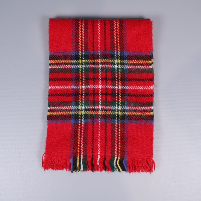 Vikta halsduken med rutigt mönster och fransar syns tydligt