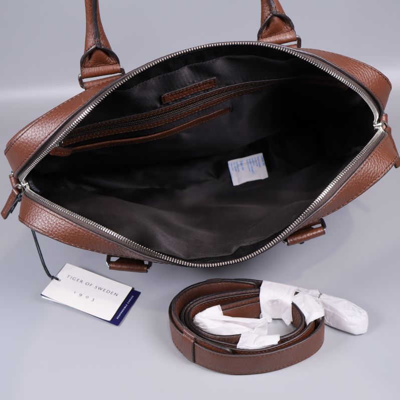 Insida av brun datorväska och avtagbar rem