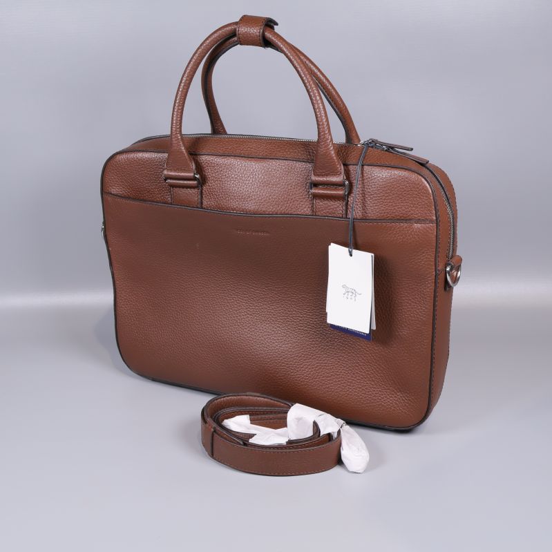 Brun datorväska med axelrem i förgrunden