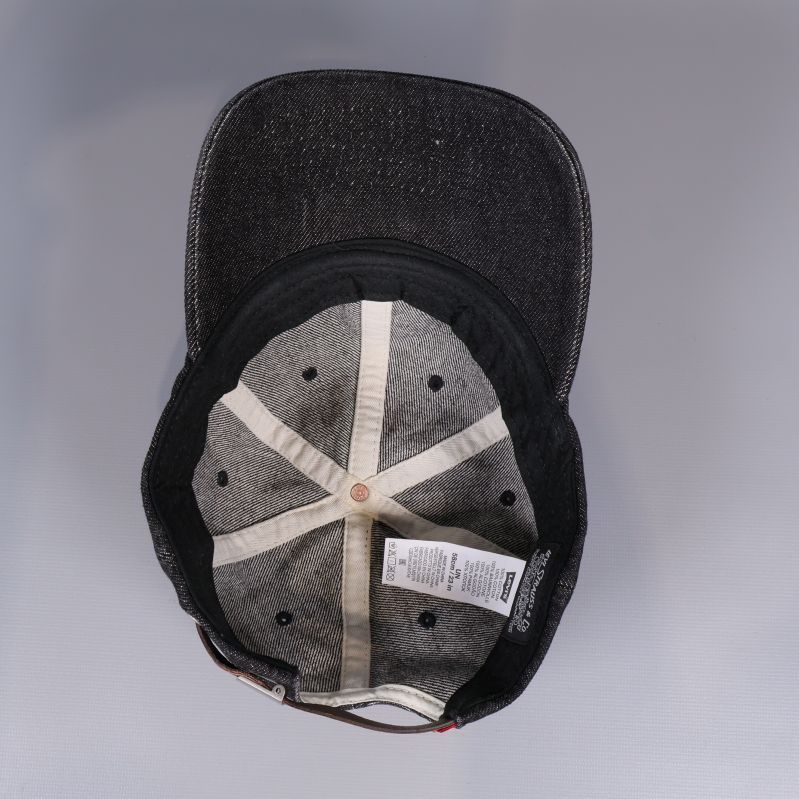 Insidan av denimkepsen med etiketter och sömmar synliga