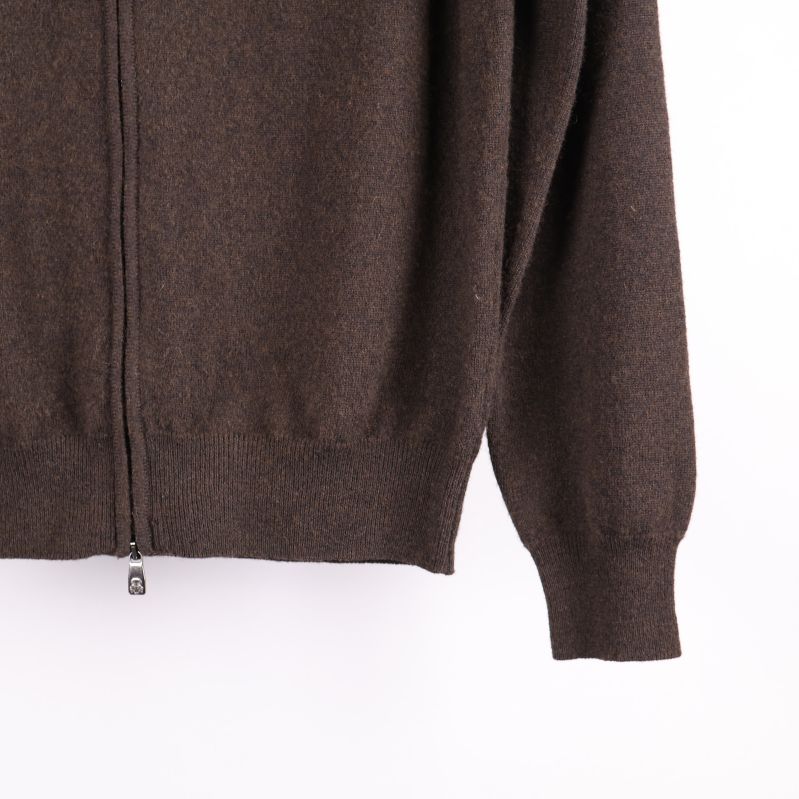 Närbild på ärm och nederkant på brun tröja