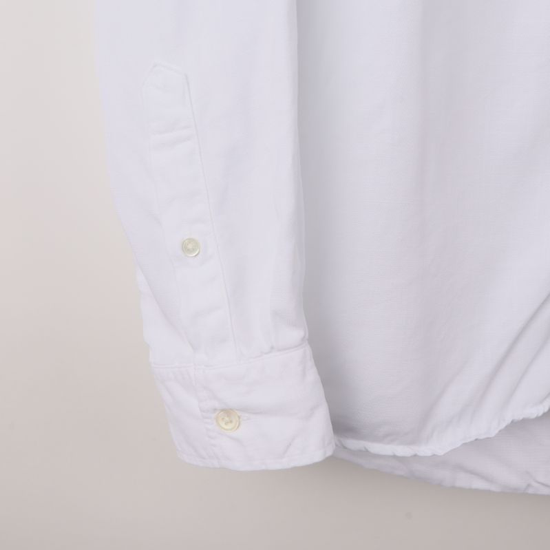 Manschett och knappdetalj på vit skjorta