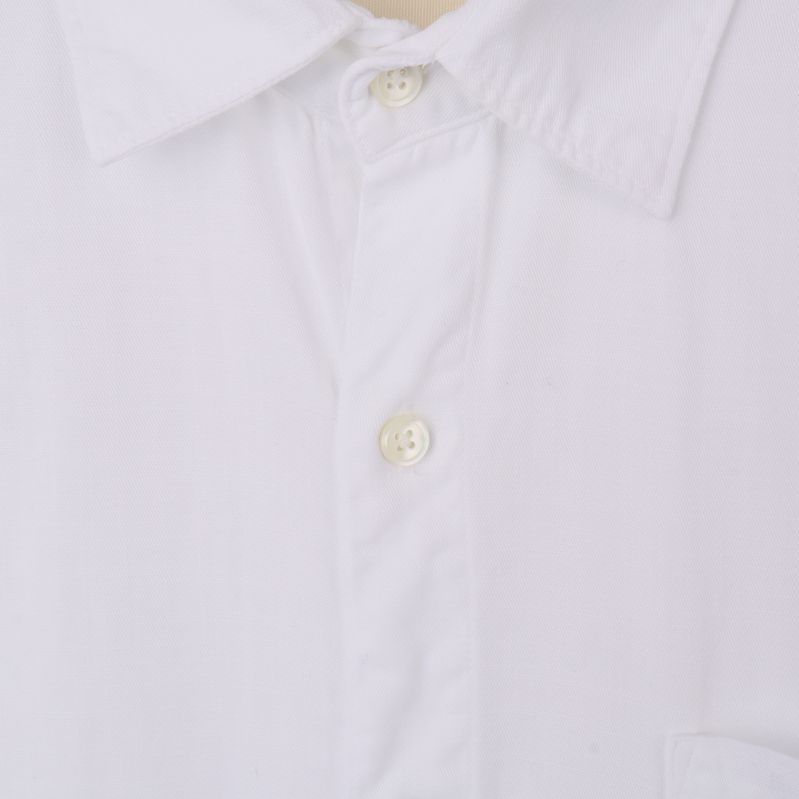 Närbild på krage och knappar på vit skjorta