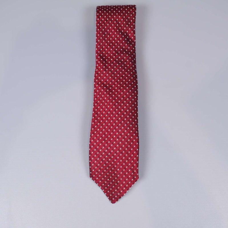 Vinröd slips med vitt mönster utlagd på bordet