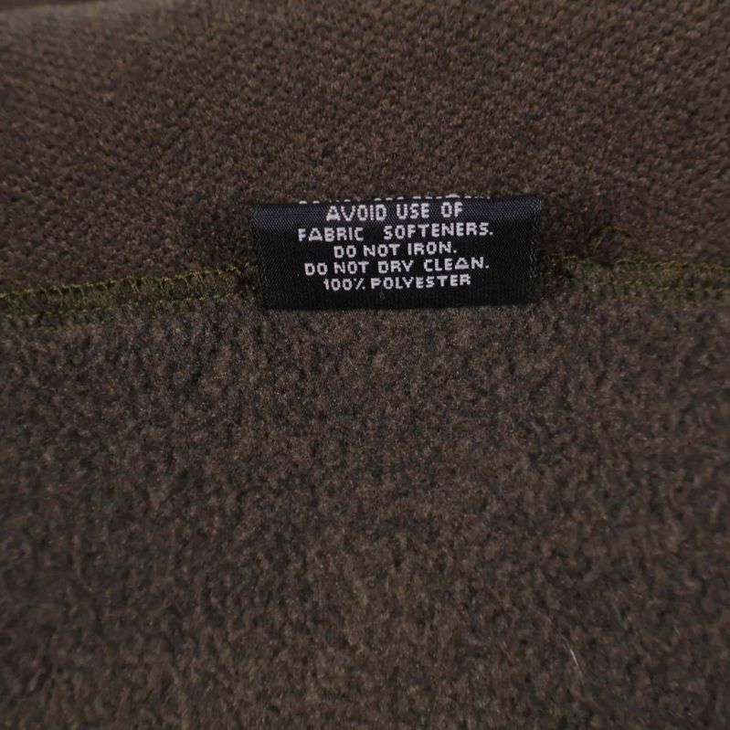 Materialetikett visar 100% polyester på fleecescarf