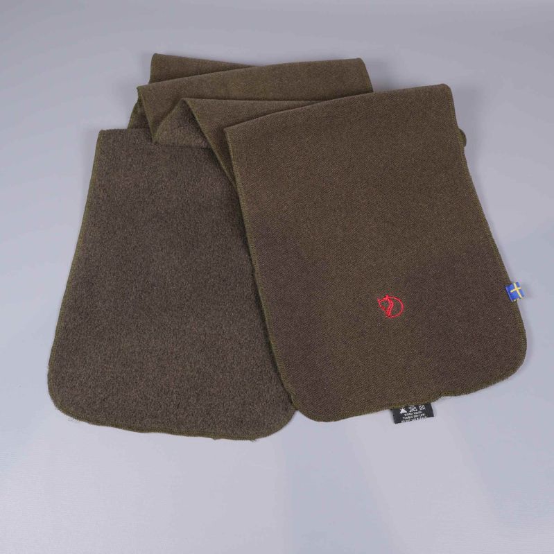 Två brungröna fleecesjalar staplade med broderad rävlåga synlig