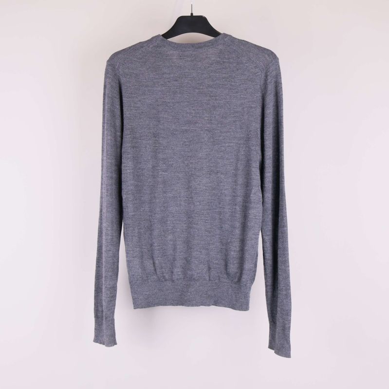 Baksidan av grå stickad tröja med långa ärmar