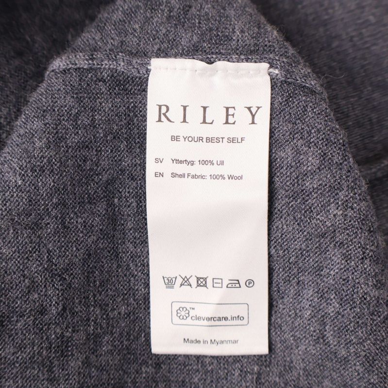 Vitt materialmärke med texten 100% ull i Riley-tröja