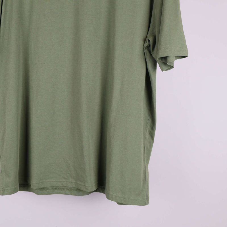 Närbild på nederdelen av grön t-shirt