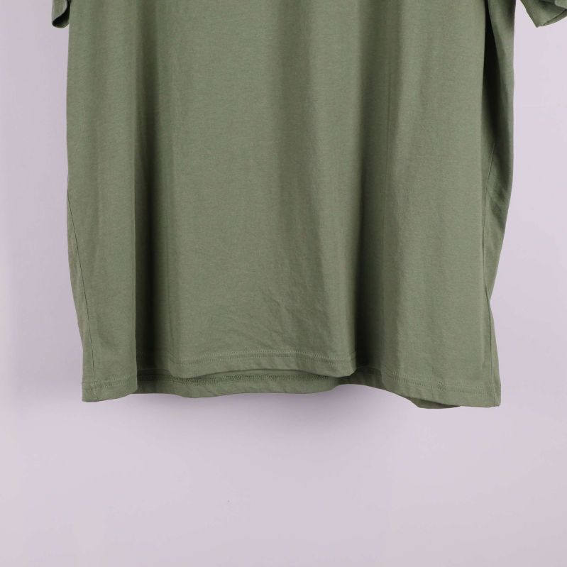 Närbild på nederkanten av grön t-shirt