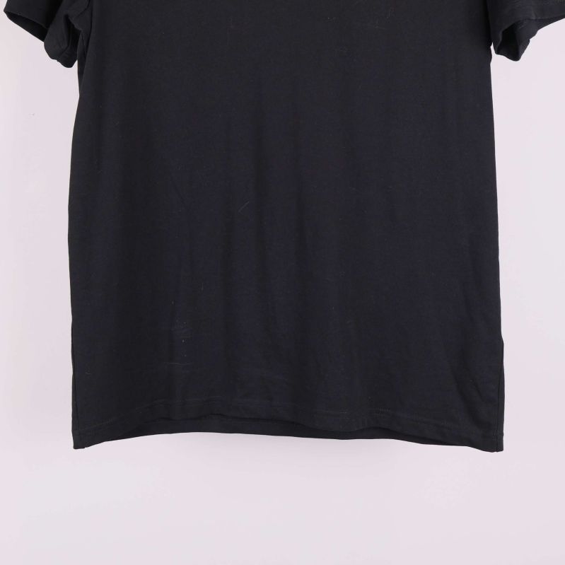 Nederkant på svart t-shirt visas i närbild