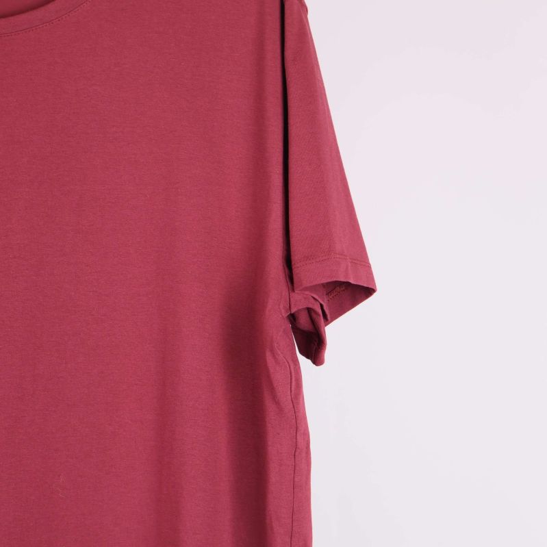 Närbild på ärm och axel av röd t-shirt