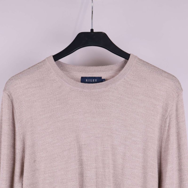 Närbild på halsringning och axlar på ulltröja