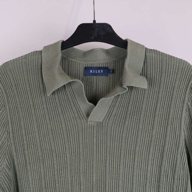 Närbild på krage och halsringning i stickad tröja