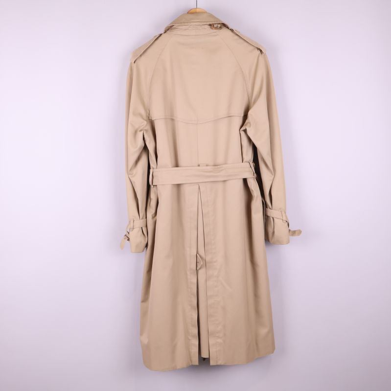 Baksida av beige trenchcoat med bälte och axelklaffar