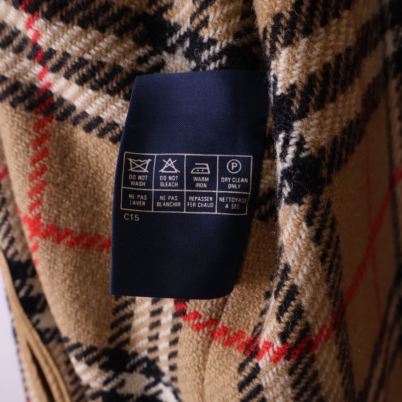 Tvättsymboler och skötselråd på etikett i kappan