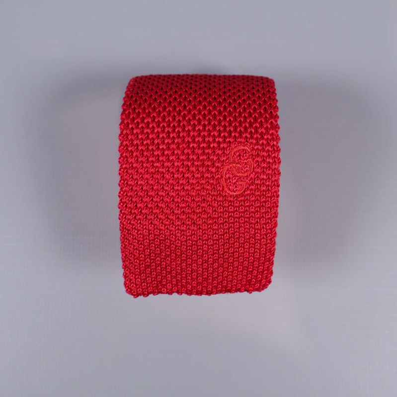 Framsida av röd stickad slips med ton-i-ton brodyr